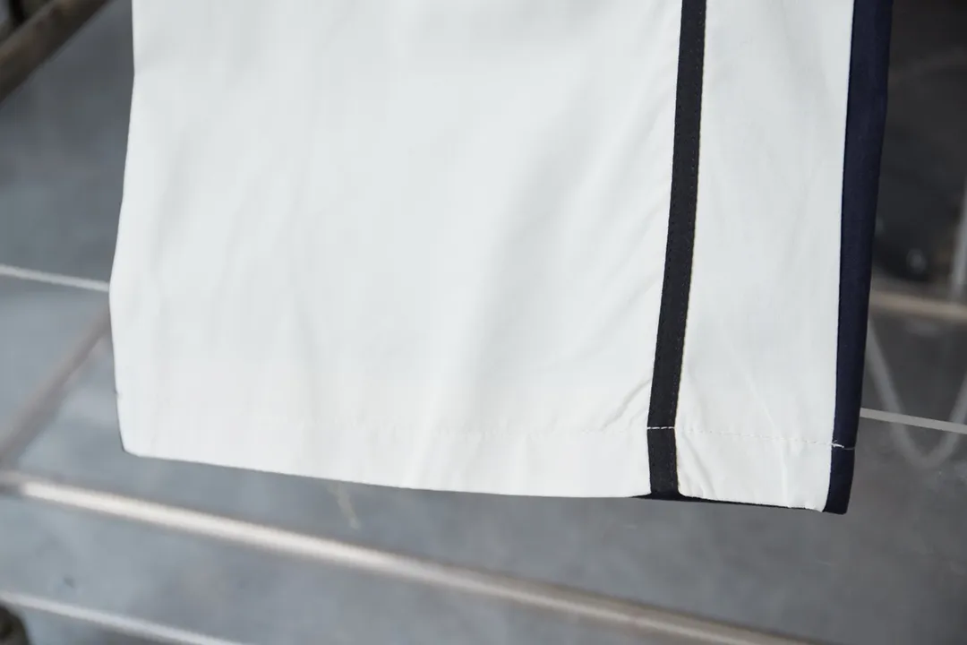 Balenciaga 𝘽𝘼𝙇𝙀𝙉𝘾𝙄𝘼𝙂𝘼 BLCG 25SS double-split waterproof sports pants. Light luxury. A must-have item for daily commuting for men and women. Correct version. Welcome to compare. Detailed features · Customized matt Taslan jacket fabric · The entire fabric is pre-treated with a waterproof coating · The interior is made of three-level polyester bird's eye mesh · OS ultra-loose silhouette design · Side pockets · Elastic waistband design · Contrast color Black webbing splicing · Front and rear contrast color splicing and cutting design · Imported Tajima machine embroidery ring logo · Original main mark washed tag brand packaging Color: White/Royal Blue Size: 46/48/50/52